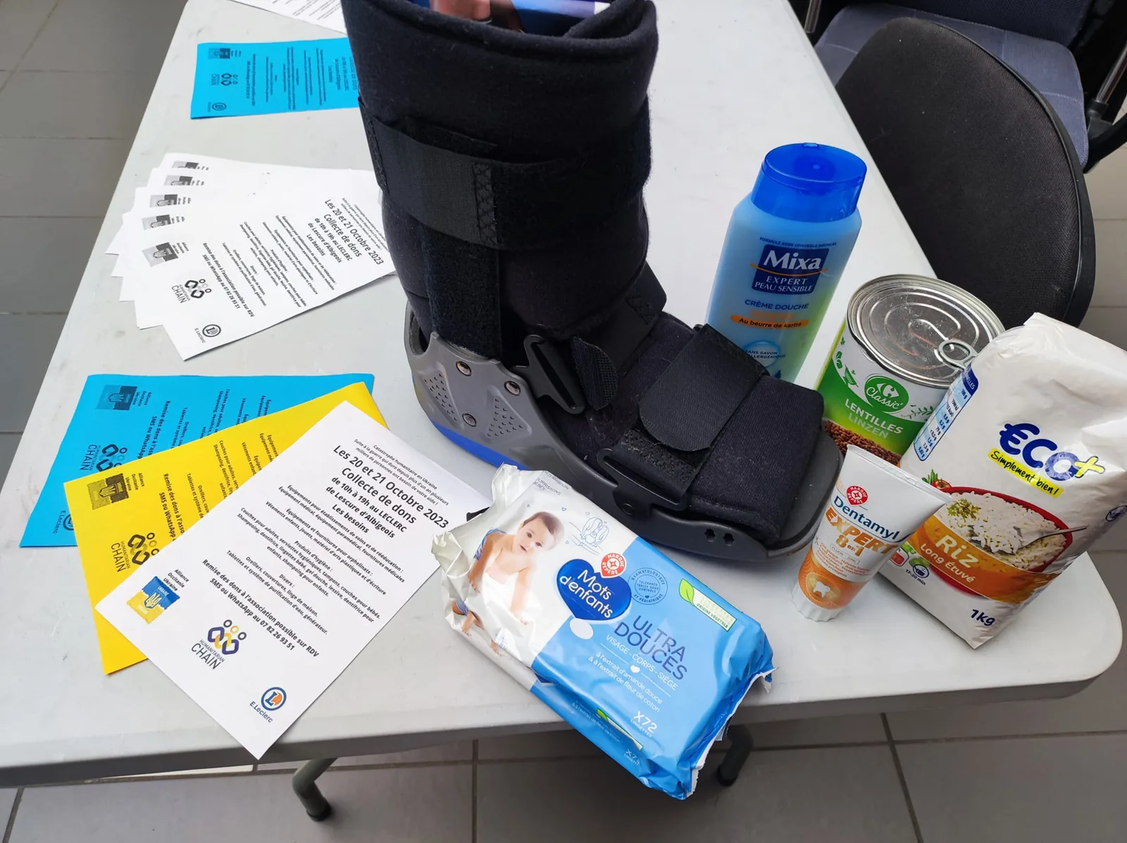 Des dons rassemblés sur une table : une attelle, des produits d’hygiène, des conserves